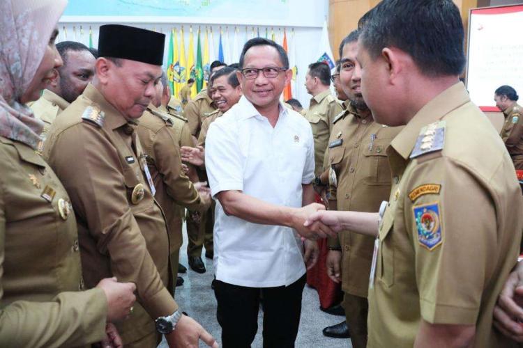 Foto Menteri Dalam Negeri Tito Karnavian Berjabat Tangan dengan Pj Bupati Aceh Besar Muhammad Iswanto SSTP MM, sembari dikelilingi sejumlah aparatur sipil negara pada Rakor Penjabat Kepala Daerah dalam Rangka Menjamin Peningkatan Kesinambungan Penyelenggaraan Pemerintahan Daerah dan Pelayanan Publik serta Implementasi Kebijakan Strategis Nasional di Daerah, di Gedung Sasana Bhakti Praja, Kantor Pusat Kemendagri, Jakarta